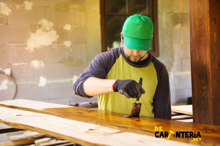 hombre-carpintero-haciendo-una-restauración-de-superficie-de-madera-a-través-de-la-aplicación-de-barniz-a-la-madera